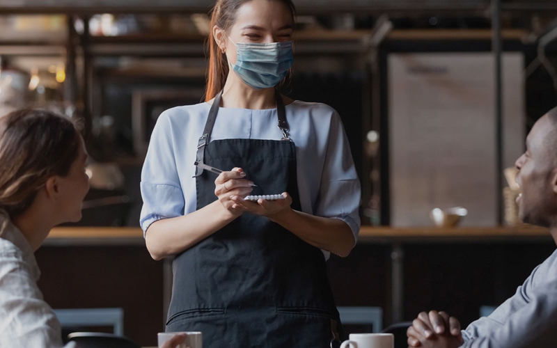 woman with mask taking orders